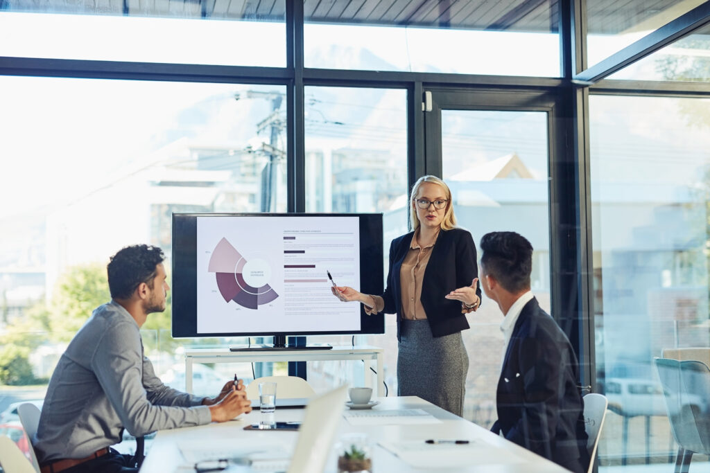 Meeting presentation and business woman with statistics for financial profit infographics or growth charts Office colleagues and person by TV for marketing data budget review or productivity