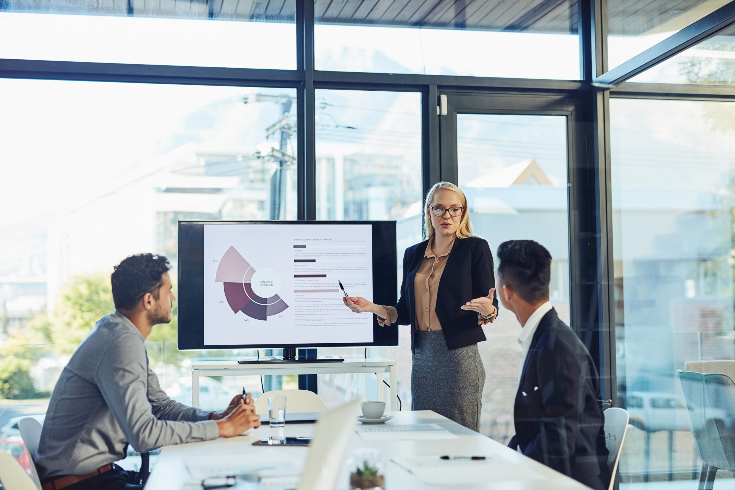 Meeting presentation and business woman with statistics for financial profit infographics or growth charts Office colleagues and person by TV for marketing data budget review or productivity